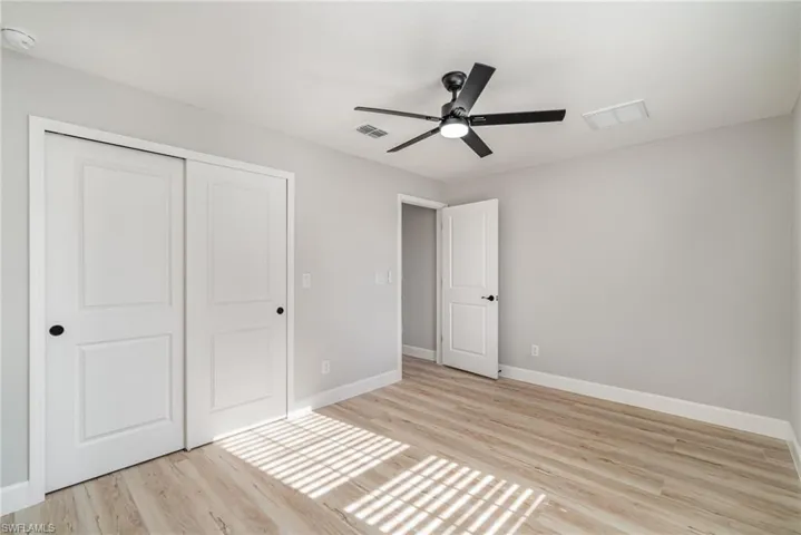 Unfurnished bedroom with light hardwood / wood-style flooring, a closet, and ceiling fan