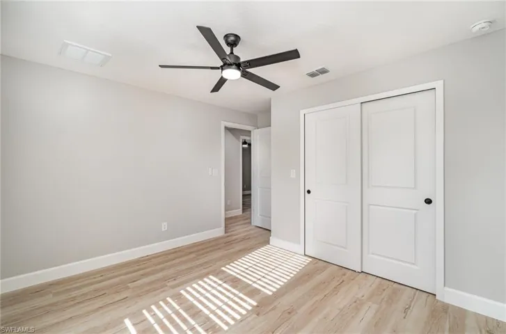 Unfurnished bedroom with light hardwood / wood-style flooring, a closet, and ceiling fan