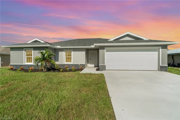 Ranch-style home with a garage and a lawn