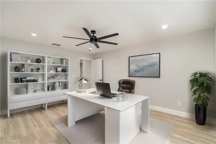 Office space with ceiling fan and light hardwood / wood-style flooring