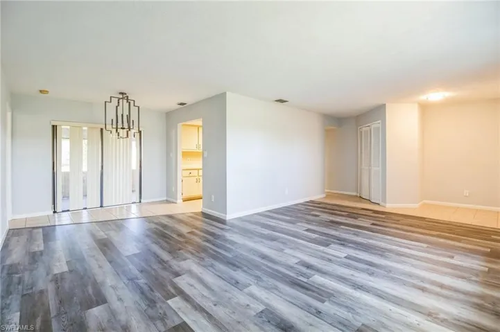 Unfurnished living room with a notable chandelier and light hardwood / wood-style floors