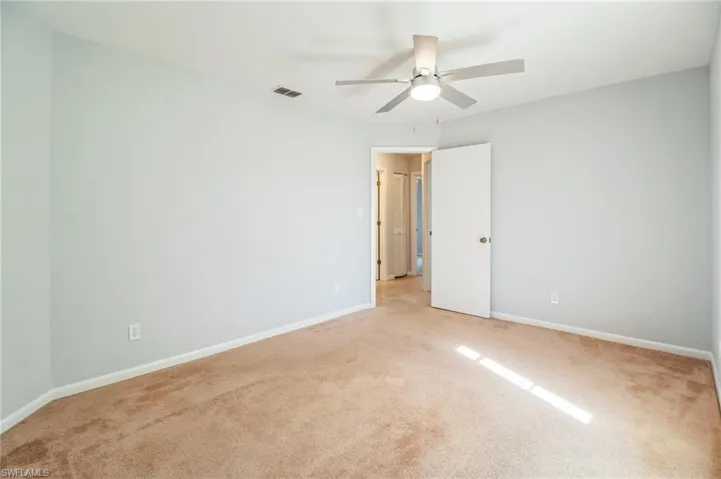 Carpeted empty room featuring ceiling fan