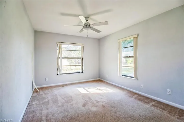 Carpeted empty room with ceiling fan