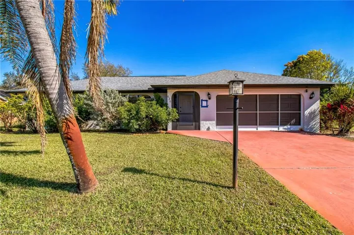 Ranch-style house featuring a garage and a front lawn