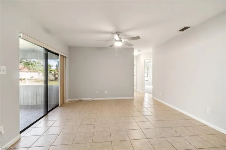 Tiled spare room featuring ceiling fan