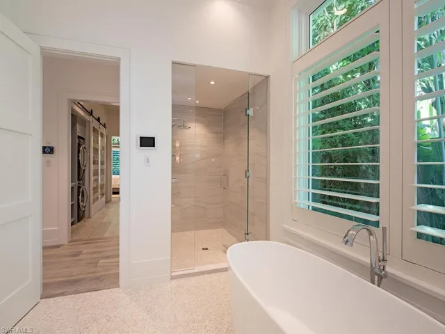 Bathroom featuring a soaking tub, a shower stall, and a walk in closet