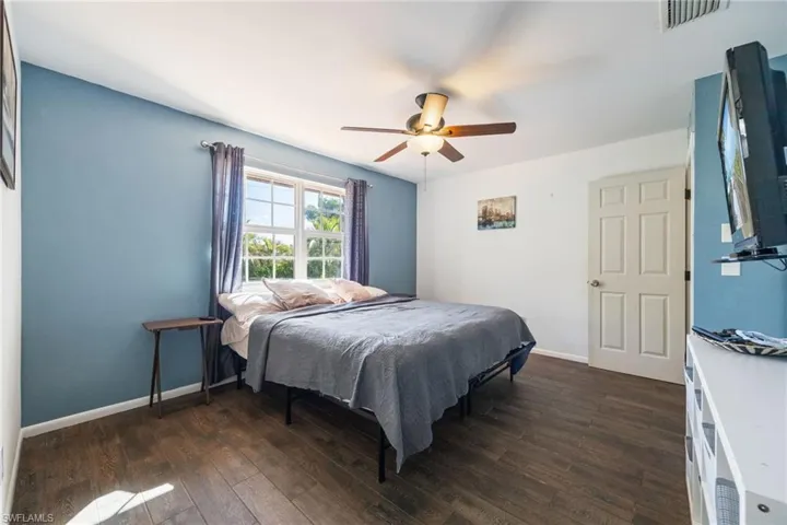 Bedroom with dark wood-type flooring and a ceiling fan