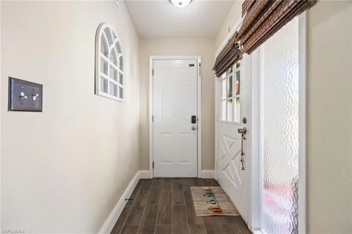 Doorway with wood tiled floors and baseboards