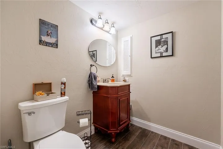 Bathroom featuring a textured wall, wood finish floors, and vanity