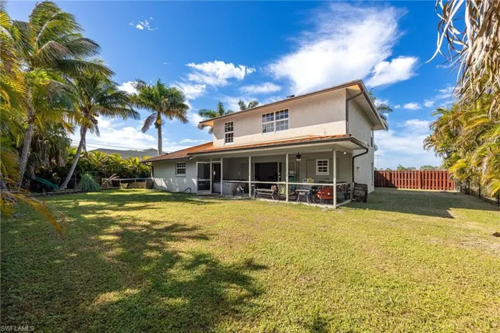 Back of property featuring stucco siding, a sunroom, a ceiling fan, and a fenced backyard