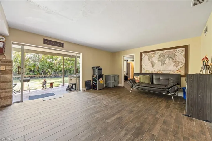 Living area with dark wood-type flooring and baseboards