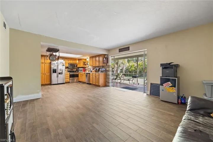 Unfurnished living room with dark wood-style flooring and baseboards