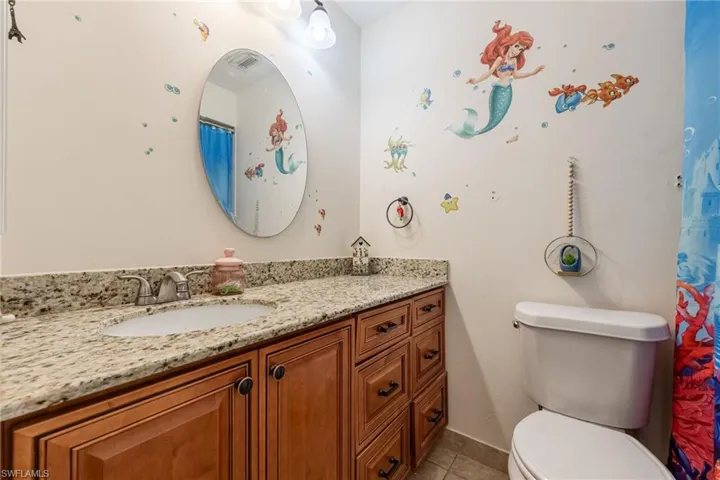 Full bath featuring curtained shower, vanity, and light tile patterned floors