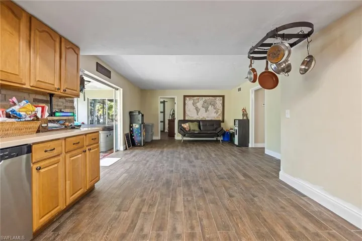 Kitchen featuring dishwasher, light countertops, tasteful backsplash, dark wood-style flooring, and brown cabinets