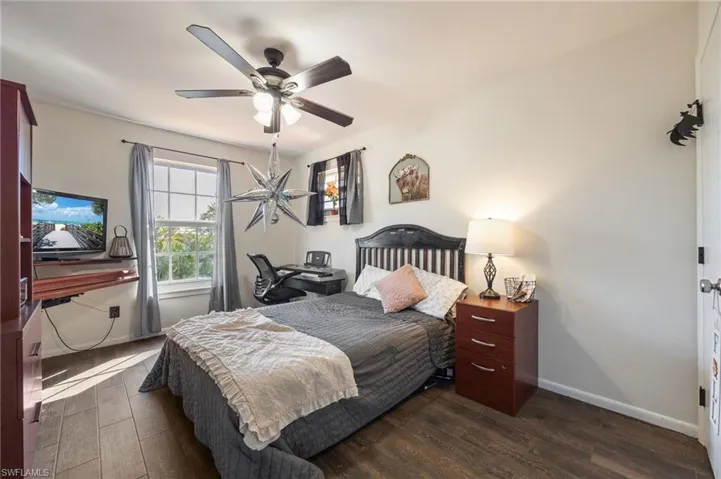 Bedroom with dark wood-style flooring and a ceiling fan