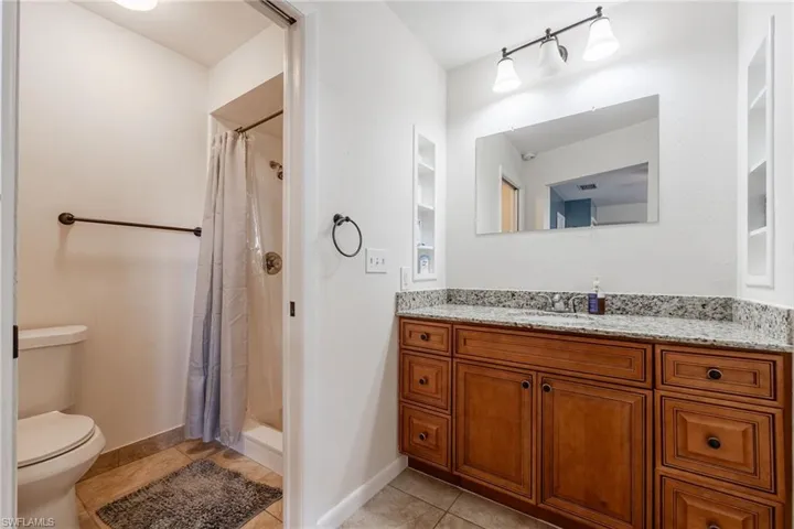 Full bathroom featuring a shower stall, vanity, and light tile patterned flooring