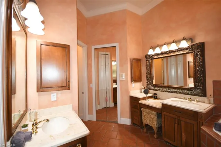 Main bathroom with dual bowl vanities, decorative mirrors & walk-in mirrored closet