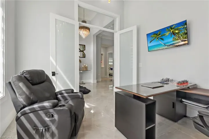 Office with an inviting chandelier and marble finish floor