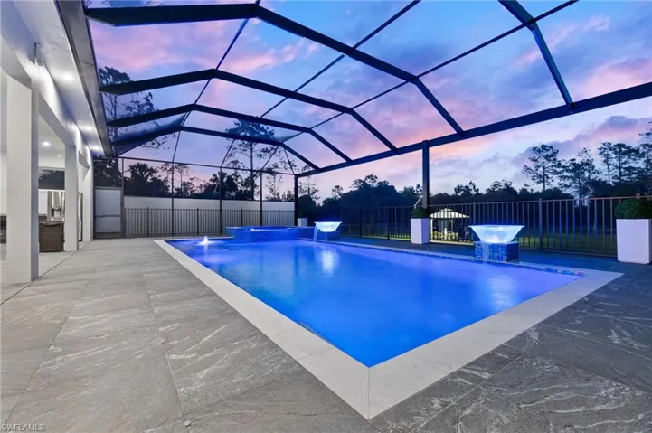 View of pool with a fenced in pool, glass enclosure, a patio, and fence
