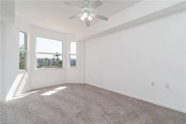 Empty room with ceiling fan, baseboards, and carpet