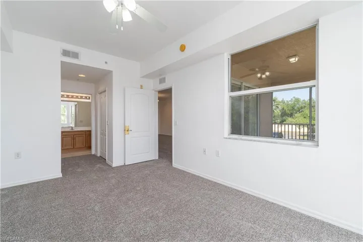 Unfurnished bedroom featuring ensuite bath, carpet, visible vents, and baseboards