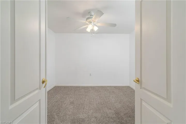 Unfurnished room with carpet floors, baseboards, and ceiling fan