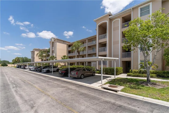 View of building exterior featuring covered parking