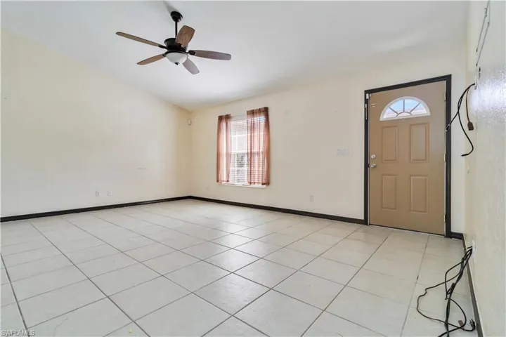 Entryway with healthy amount of natural light, light tile patterned floors, and ceiling fan