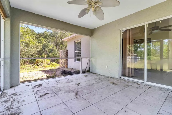 Unfurnished sunroom featuring a patio and a ceiling fan
