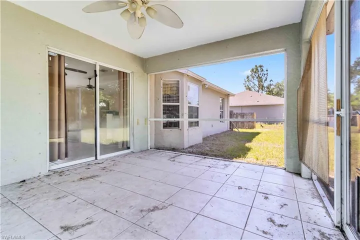 Unfurnished sunroom featuring a ceiling fan and a patio