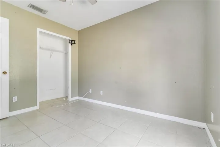 Unfurnished bedroom with light tile patterned floors, a closet, and ceiling fan