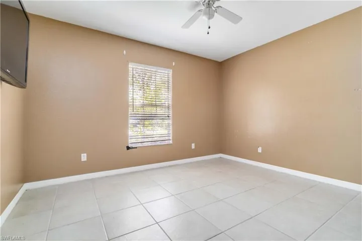 Unfurnished room with light tile patterned floors and ceiling fan