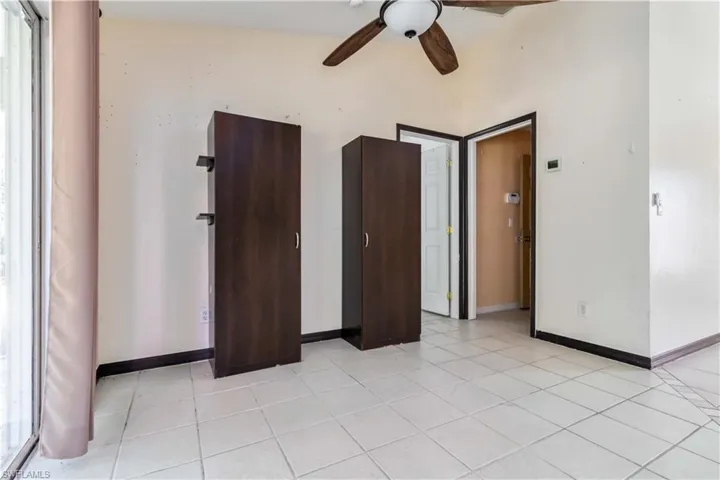 Unfurnished bedroom featuring light tile patterned floors and a ceiling fan