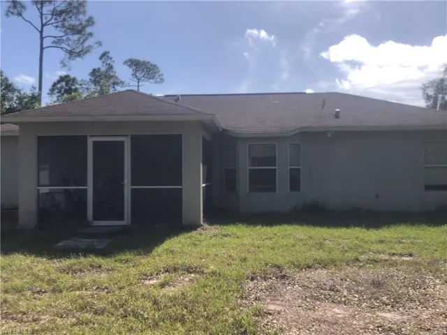 Ranch-style house with stucco siding, a front lawn, driveway, and a garage