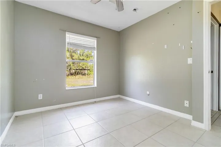 Spare room with light tile patterned floors and ceiling fan