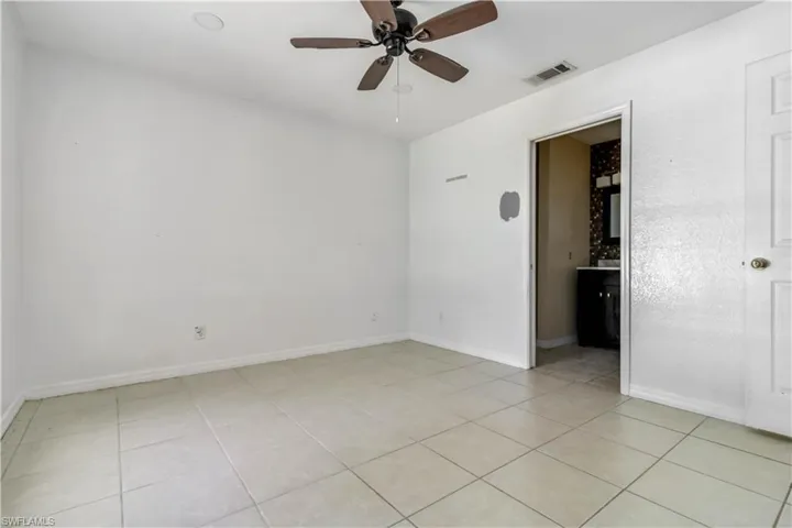 Empty room featuring light tile patterned floors and a ceiling fan