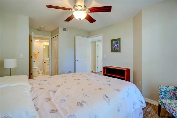 Bedroom featuring connected bathroom, wood finished floors, ceiling fan, and a closet