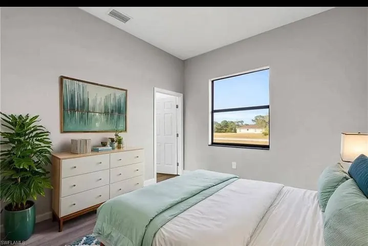 Bedroom with dark wood-style flooring and baseboards
