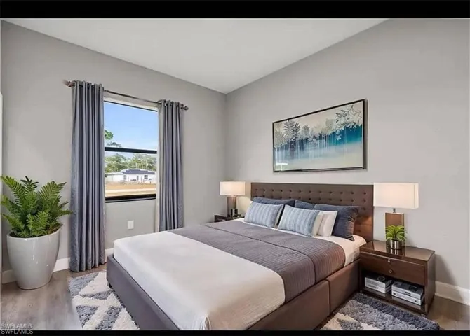 Bedroom featuring wood finished floors and baseboards