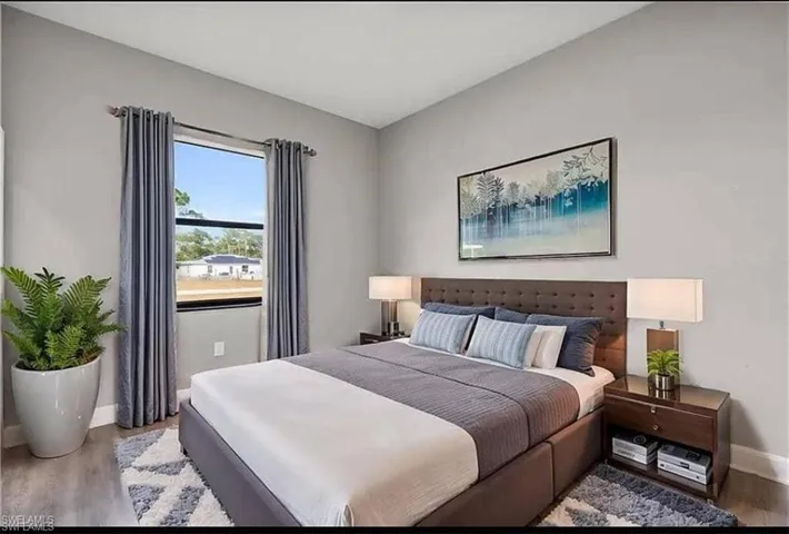 Bedroom with wood finished floors and baseboards