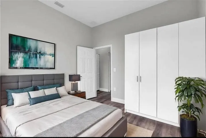 Bedroom featuring dark wood finished floors and baseboards