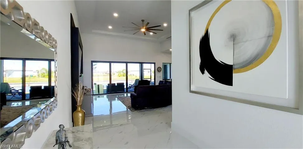 The property features high ceilings with recessed lighting, a ceiling fan, and expansive glass doors that open to an outdoor area