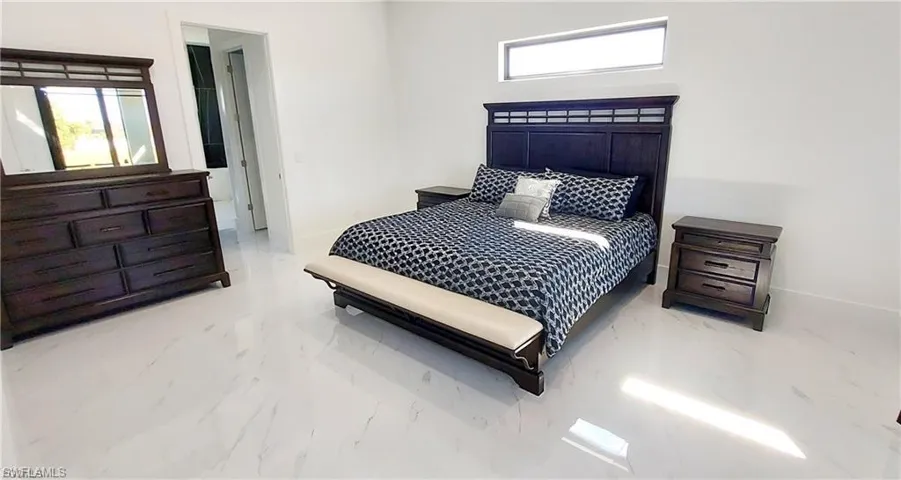 Bright room featuring white walls and white tile flooring, with a horizontal window providing natural light