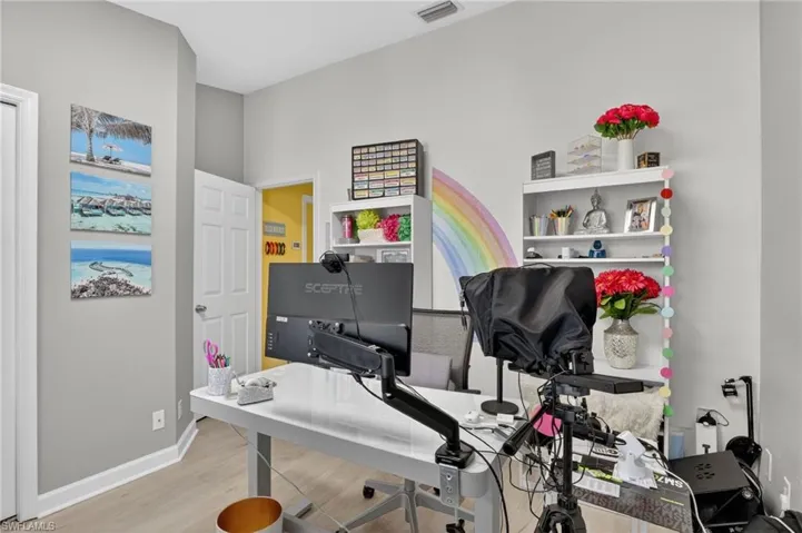 Guest bedroom/Office with light wood-style floors and baseboards