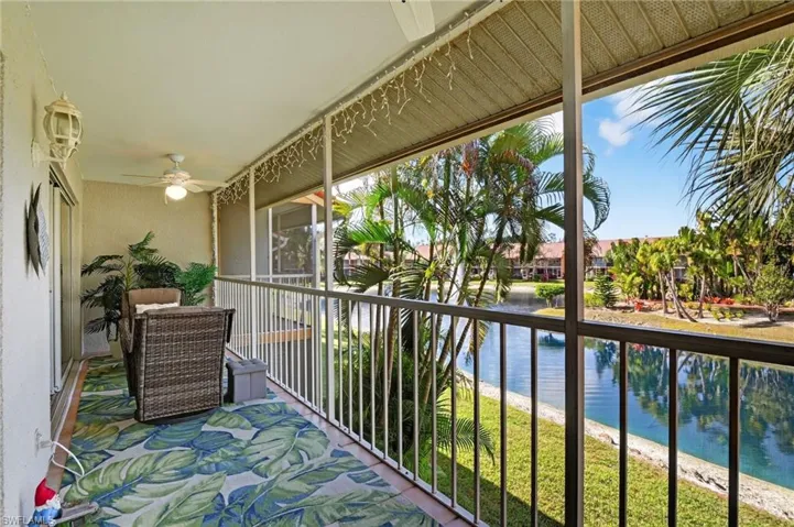 Balcony featuring a sunroom, a water view, and a ceiling fan