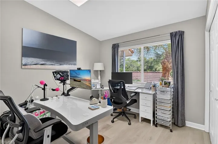 This room truly has gray walls Office space featuring lofted ceiling and light wood-type flooring