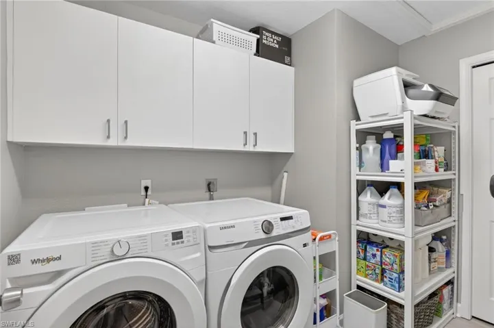 This room truly has gray walls Laundry room with independent washer and dryer and cabinet space
