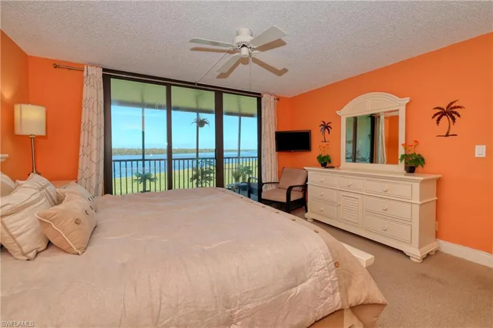 Bedroom featuring access to exterior, carpet floors, floor to ceiling windows, a ceiling fan, and a textured ceiling