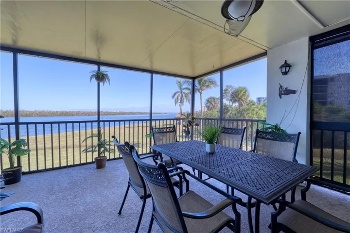 Sunroom / solarium featuring floor to ceiling windows, a water view, plenty of natural light, and carpet floors