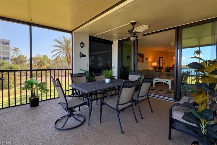 Sunroom / solarium featuring outdoor dining space, healthy amount of natural light, and a ceiling fan